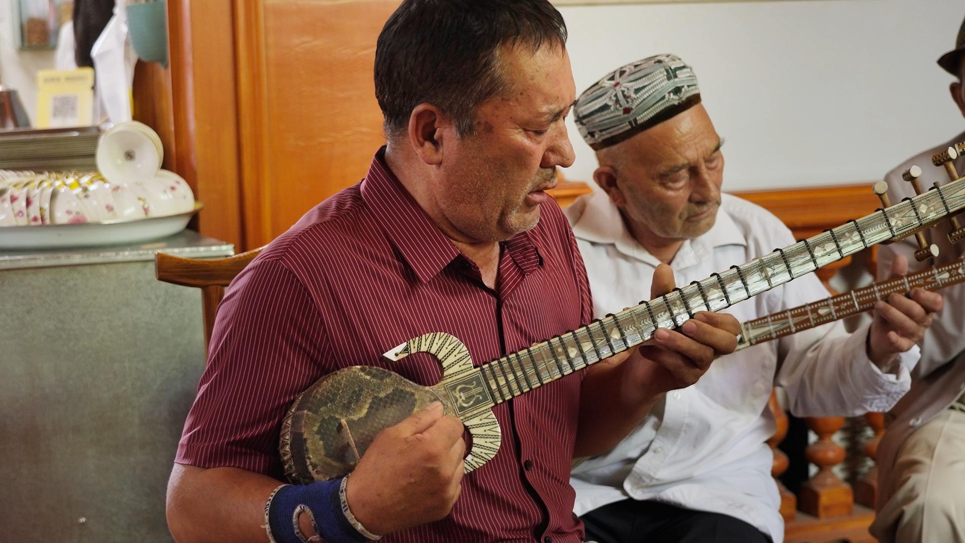 维族大叔在新疆喀什茶馆演奏乐器的预览图