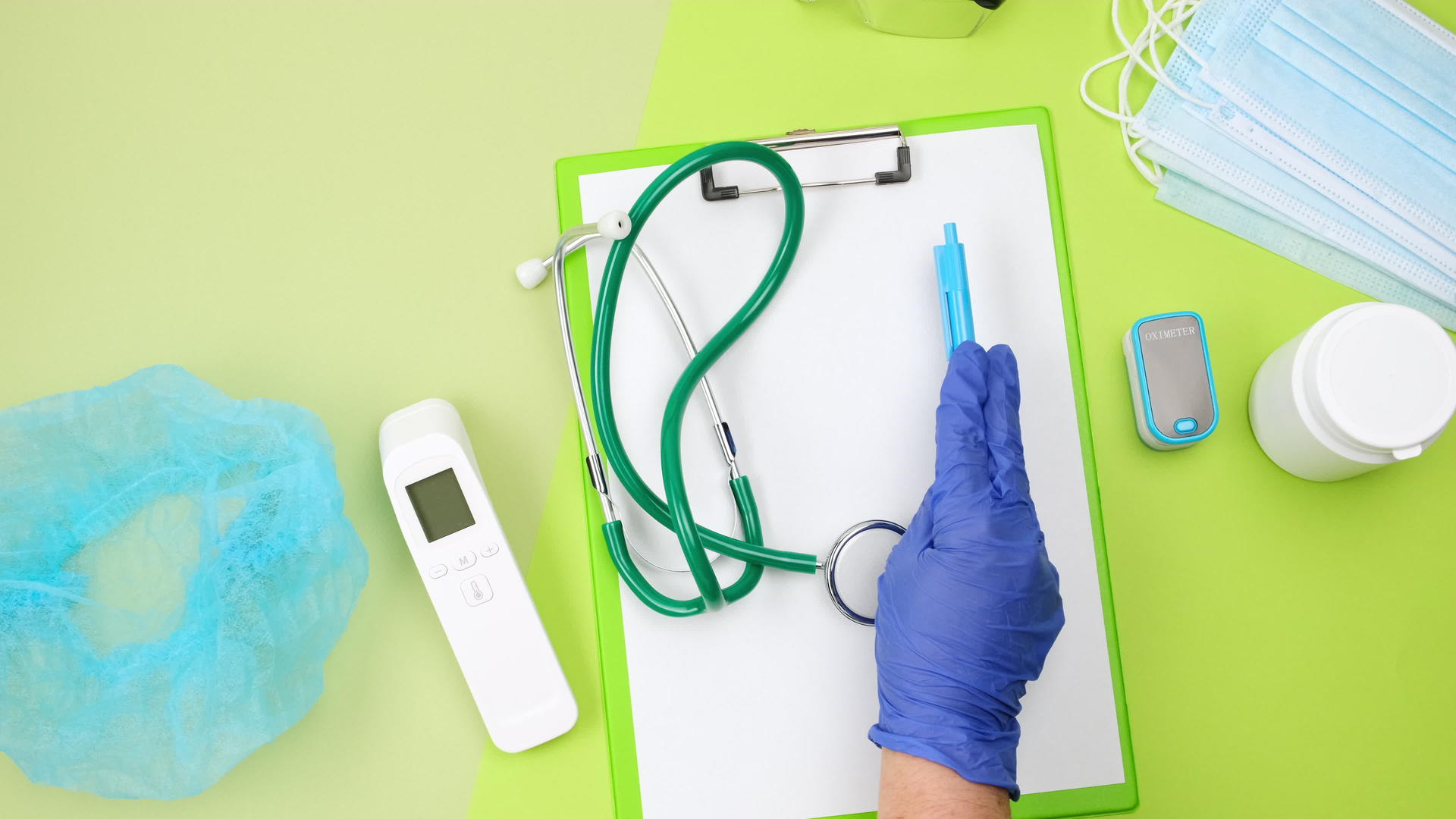 蓝色乳胶手套把医疗用品放在绿色桌子上听诊器温度计视频的预览图