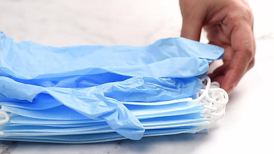 一堆医用一次性口罩蓝色乳胶手套放在桌子上视频的预览图