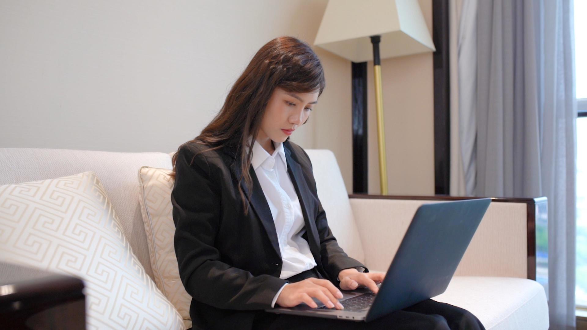 商务女性坐在沙发上使用笔记本电脑视频的预览图