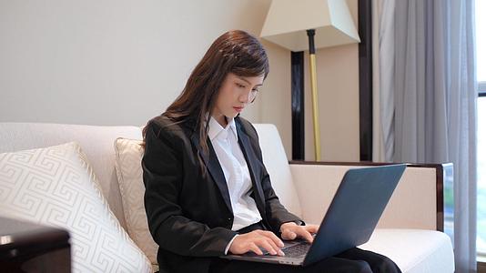 商务女性坐在沙发上使用笔记本电脑视频的预览图