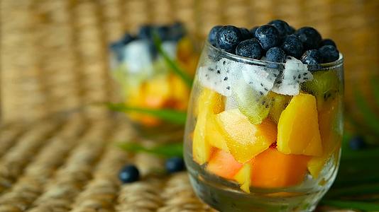 玻璃碗中放置各种新鲜有机果汁和水果的健康素食者；视频的预览图