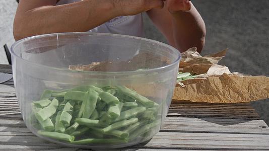 绿色法国豆一个女人手切豆子视频的预览图