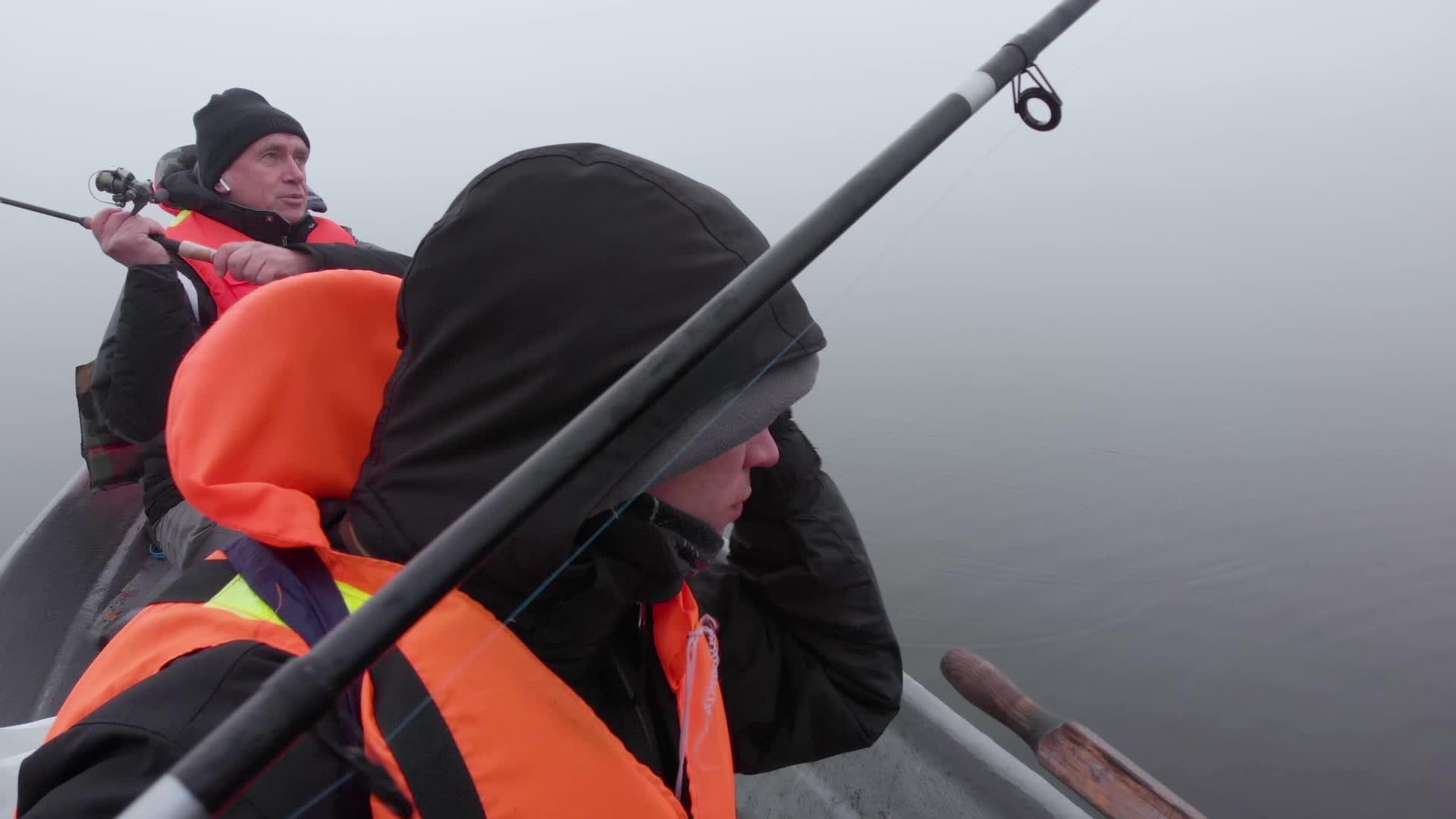 父亲和儿子在芬兰湖雾中从船上钓鱼视频的预览图