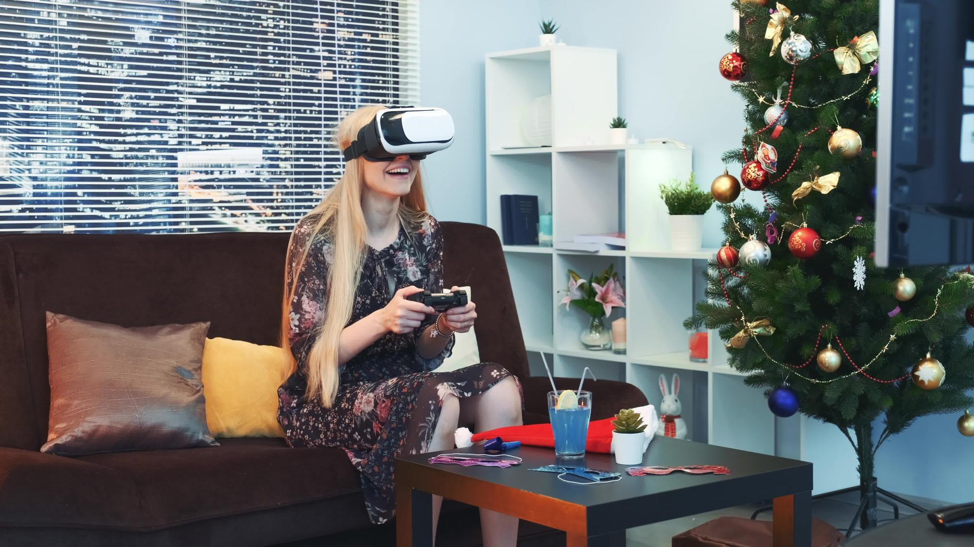 快乐的女人在虚拟现实的眼镜里玩游戏在圣诞节用棍子玩游戏视频的预览图