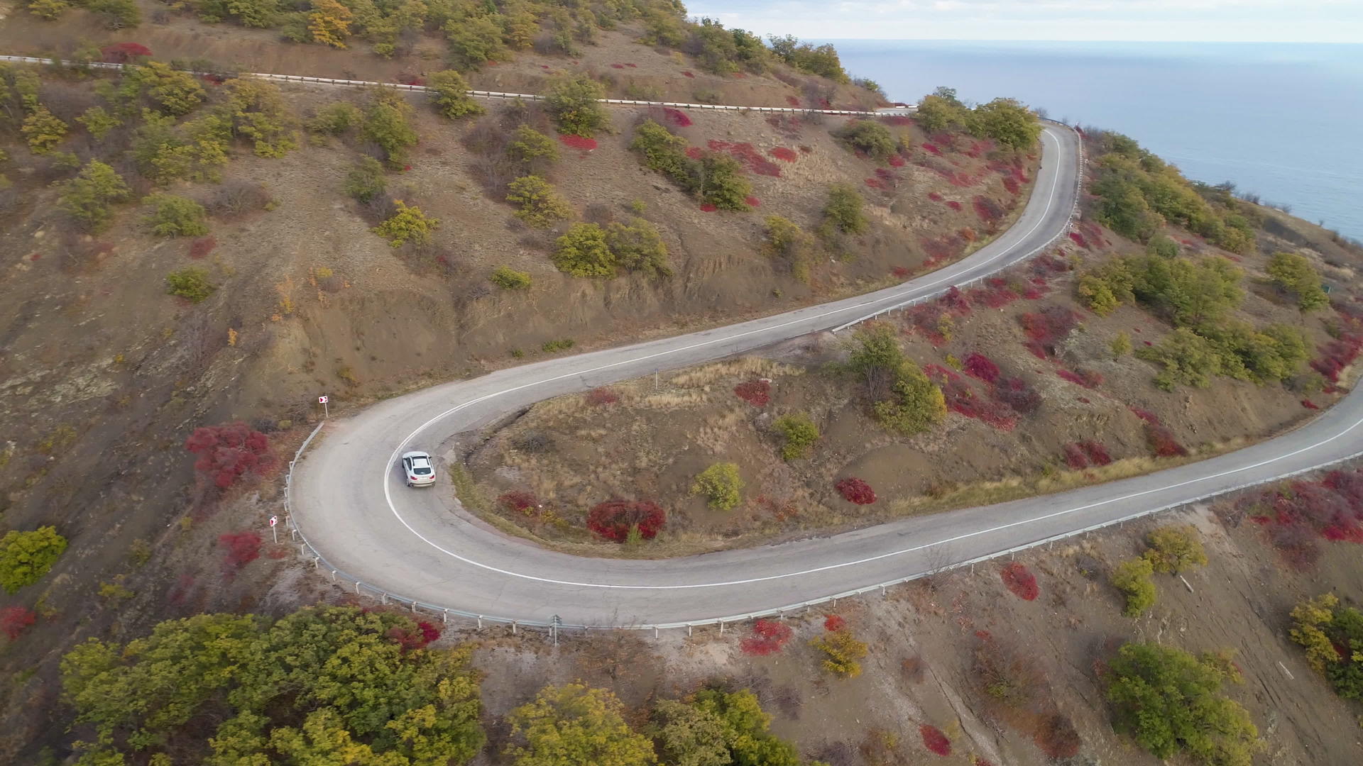 白色越野车在蛇纹山路空中飞行观察无人飞机视频的预览图