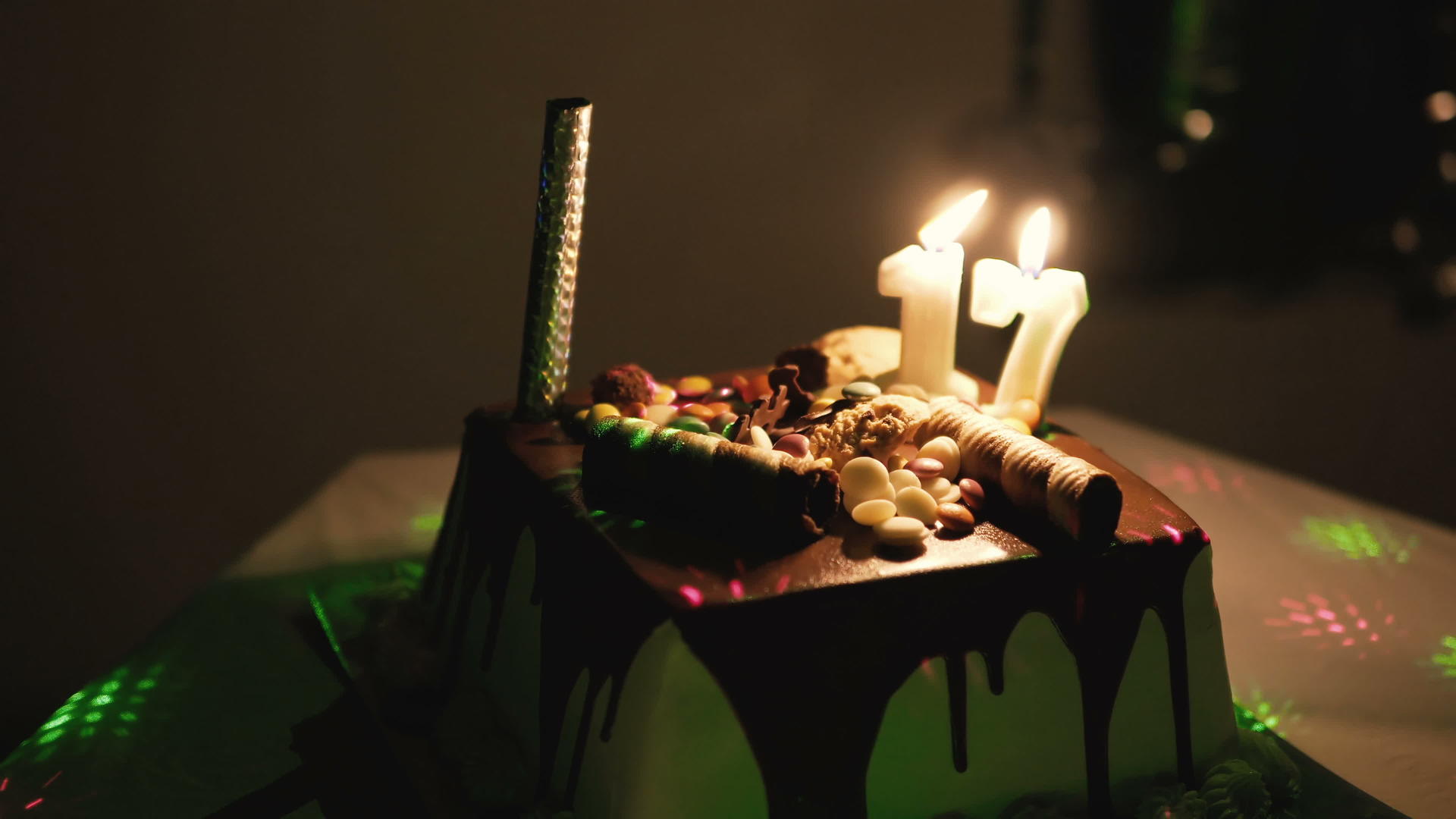 迪斯科灯光和装饰蛋糕在青年生日派对上点燃蜡烛视频的预览图