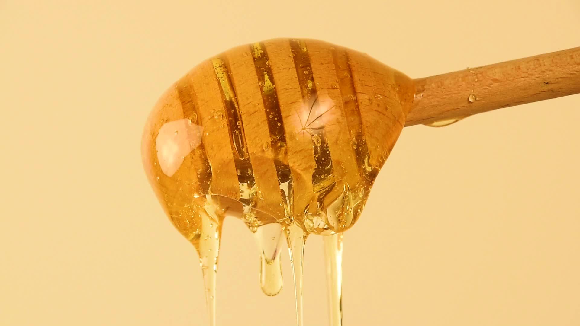 封闭的蜂蜜从米边的木尖流出视频的预览图