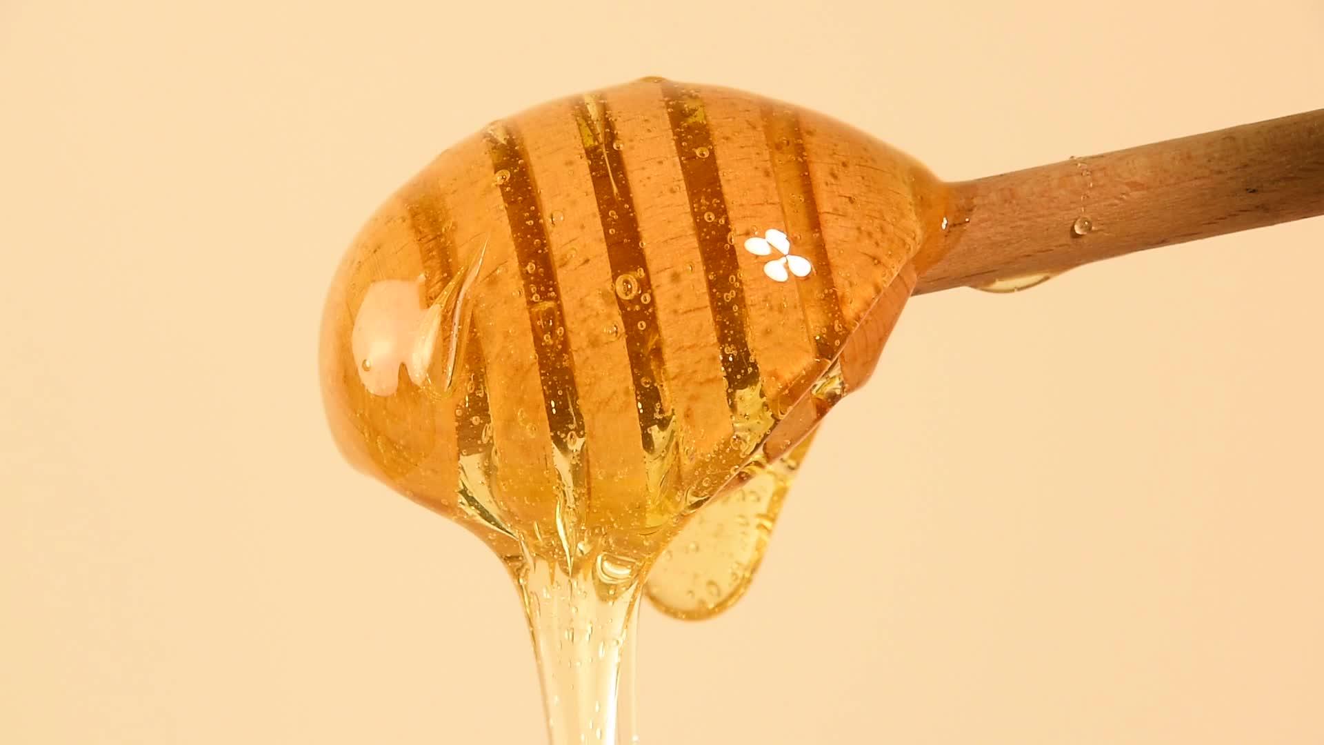 封闭的蜂蜜从米边的木尖流出视频的预览图