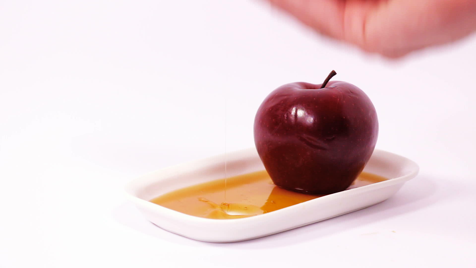 白色背景的蜂蜜和红苹果切片视频的预览图