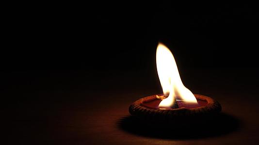 蜡烛在黑暗中的小陶器容器中熄灭视频的预览图