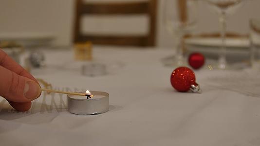 圣诞装饰和桌上的烛光男人用美丽的散乱景色点燃蜡烛视频的预览图
