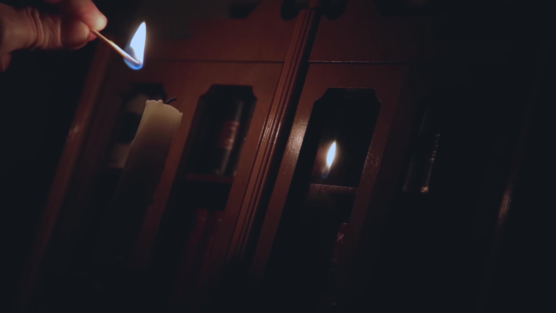 在黑暗中 男人手牵手点燃旧蜡烛根的火柴视频的预览图