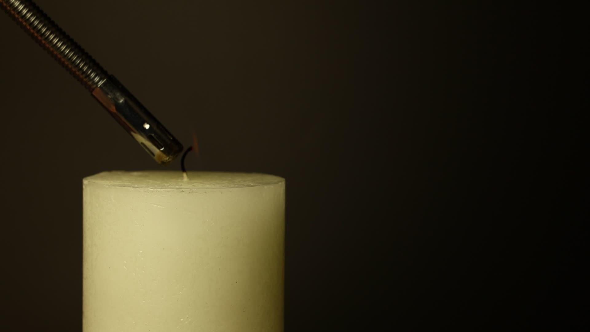 白色的蜡烛在黑色上颤抖火焰在黑色上颤抖视频的预览图