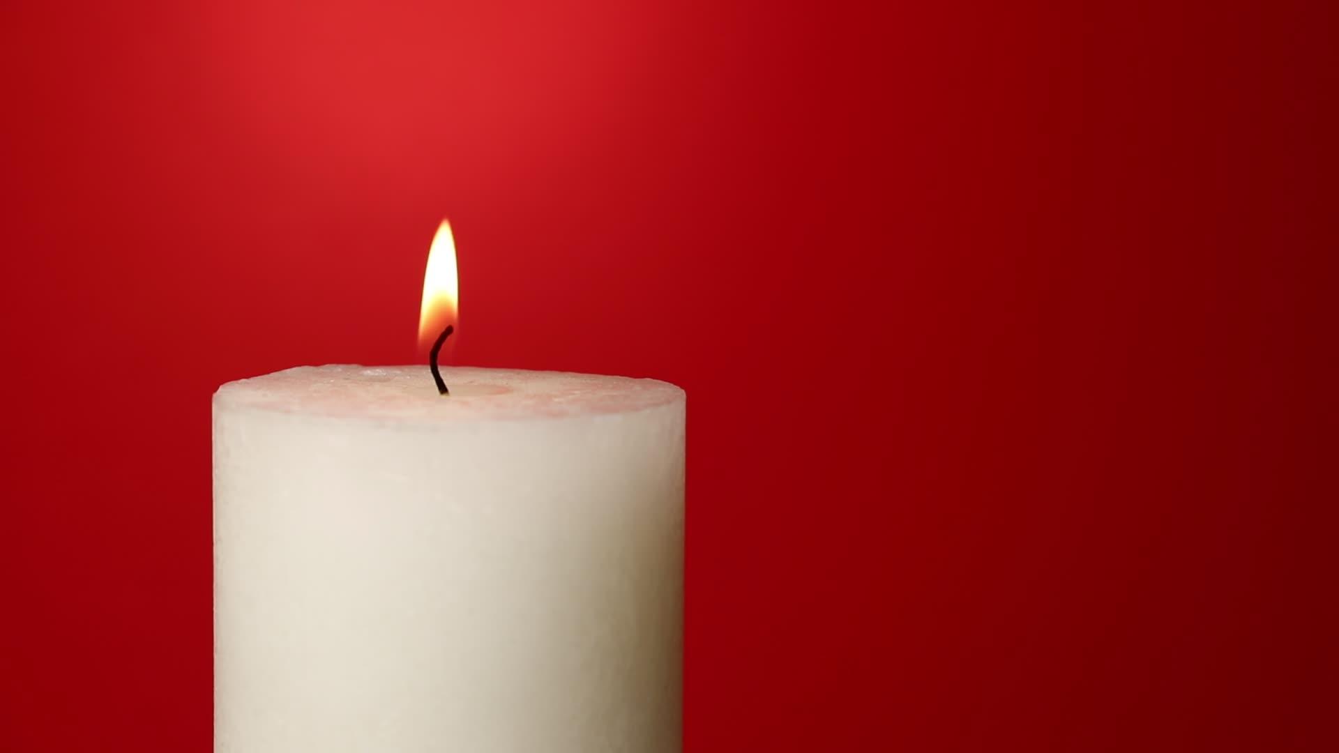 白色的蜡烛在红色的火焰上颤抖视频的预览图