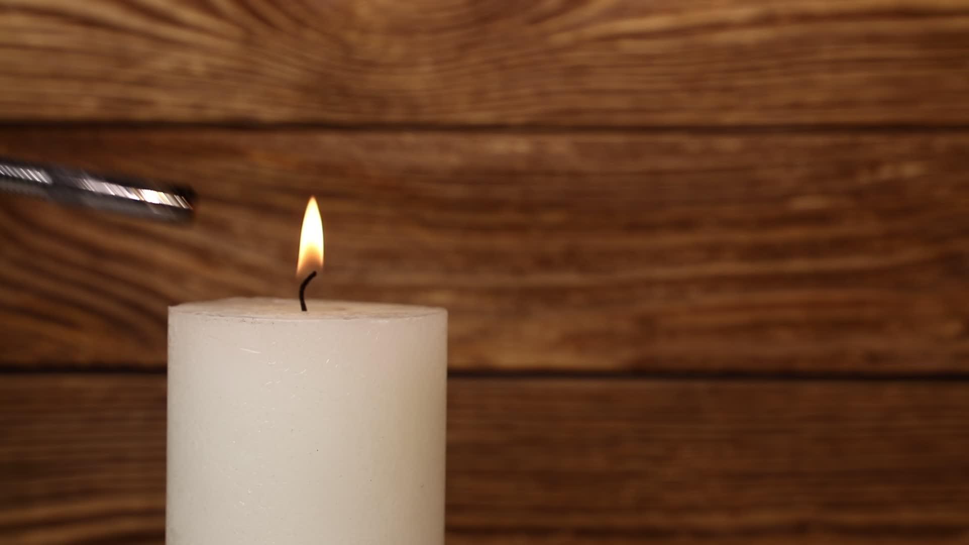 白色的蜡烛在木头上颤抖火焰在颤抖视频的预览图