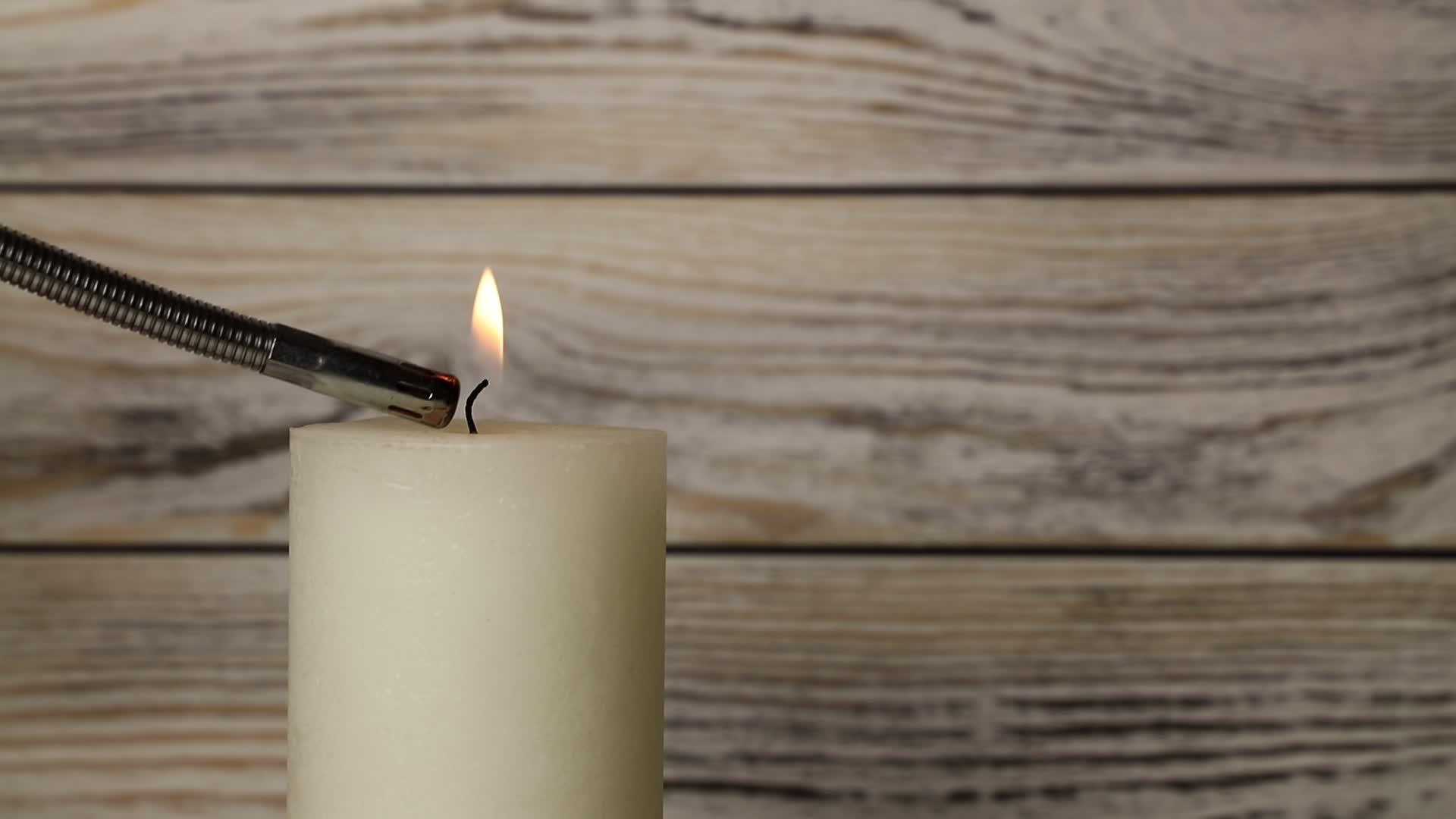 白色的蜡烛在木头上颤抖火焰在颤抖视频的预览图