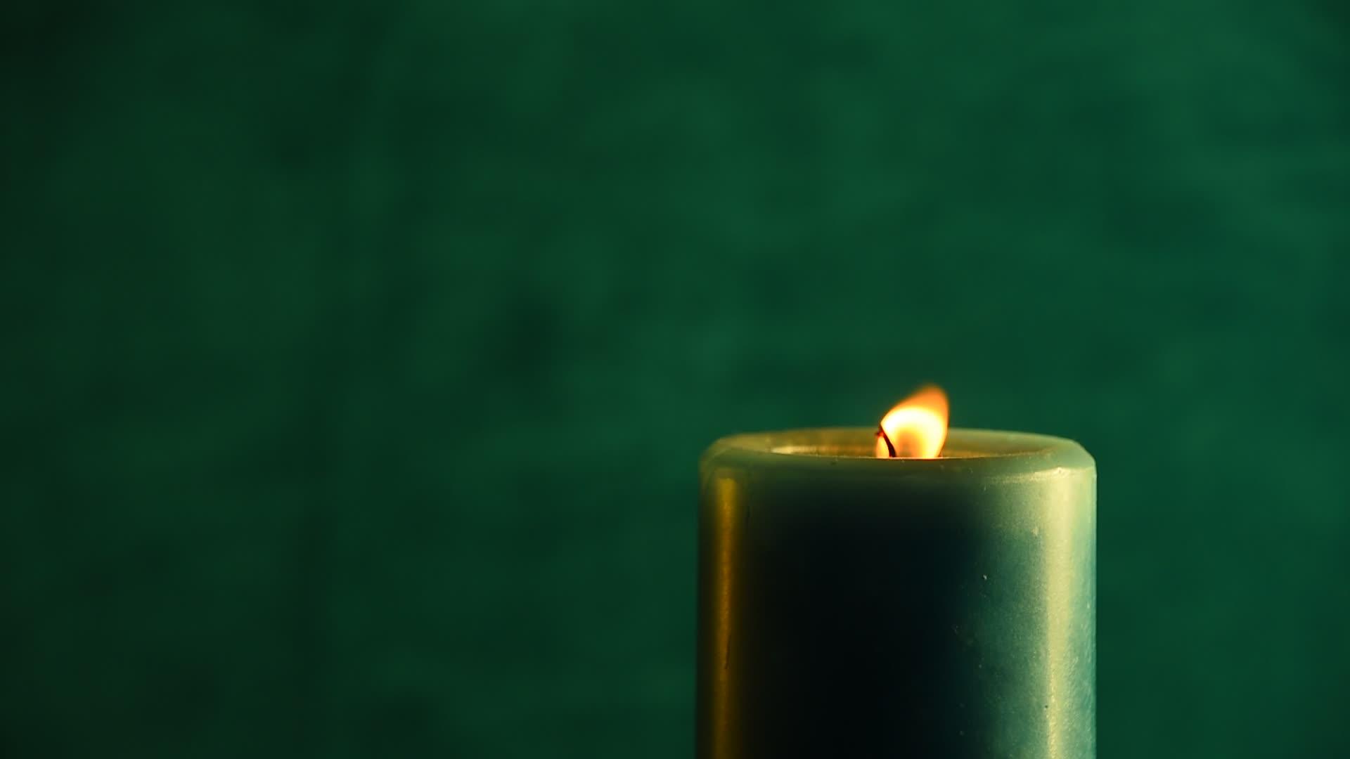 锋利的蜡烛从绿色的火焰中颤抖然后吹灭视频的预览图