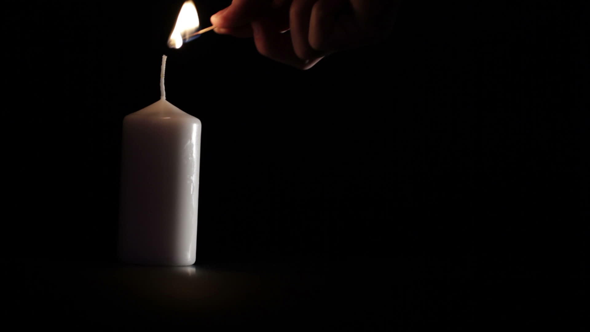 简单的白色蜡烛在黑色背景上视频的预览图