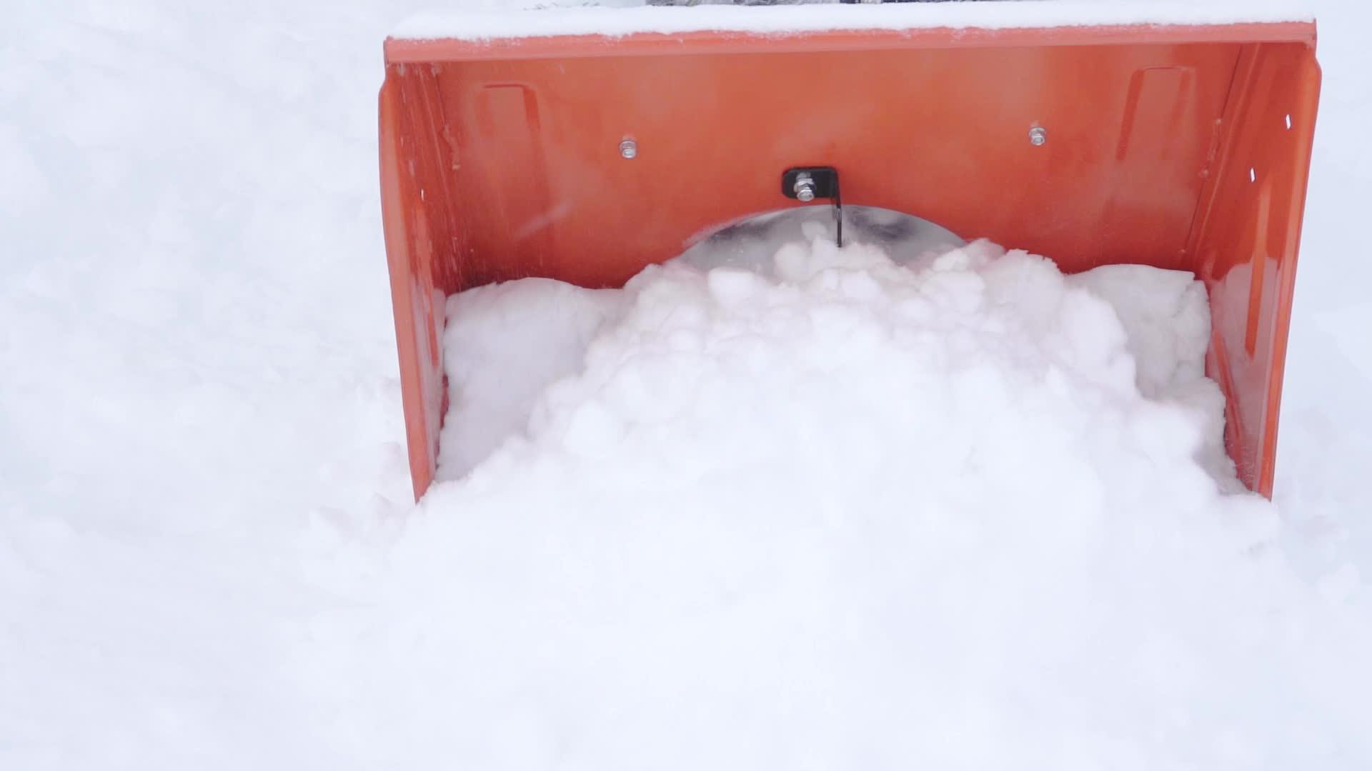冬天吹雪者充满了雪桶和雪下雪后排雪的过程视频的预览图