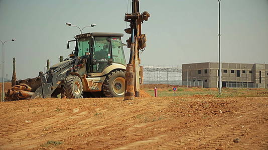 在建筑工地安装钻井装置的拖拉机视频的预览图