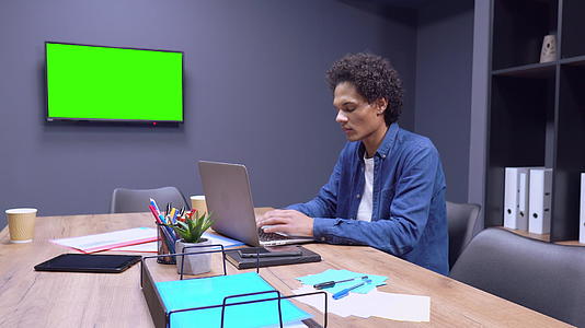 混血男子在笔记本电脑上工作视频的预览图