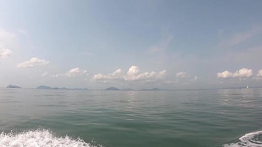 在海上的水下岛和明亮天空的云层上喷洒水面岛屿视频的预览图