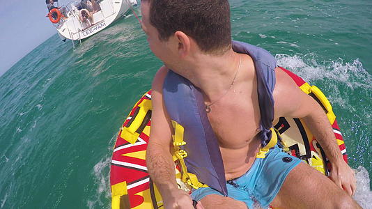 坐在充气环上的那个人被拖进水里然后用相机录下了自己视频的预览图