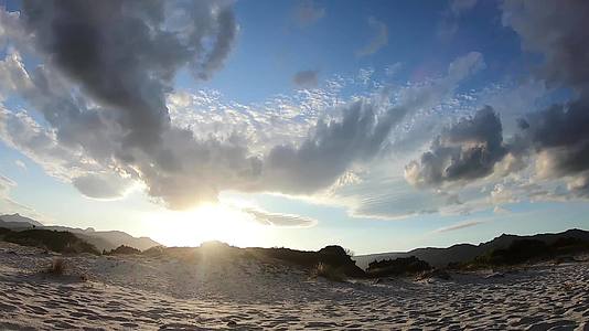 日落时空消失了云遮住了太阳照亮了沙丘然后在地平线上视频的预览图