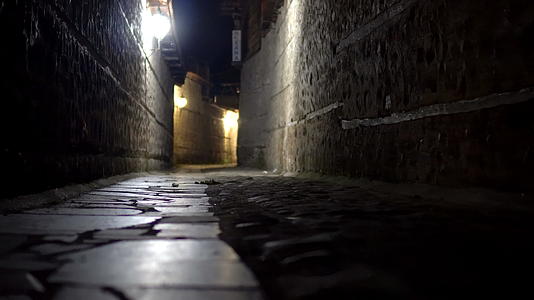 在神秘狭窄的小巷里移动第一个视角 晚上带着石路灯视频的预览图
