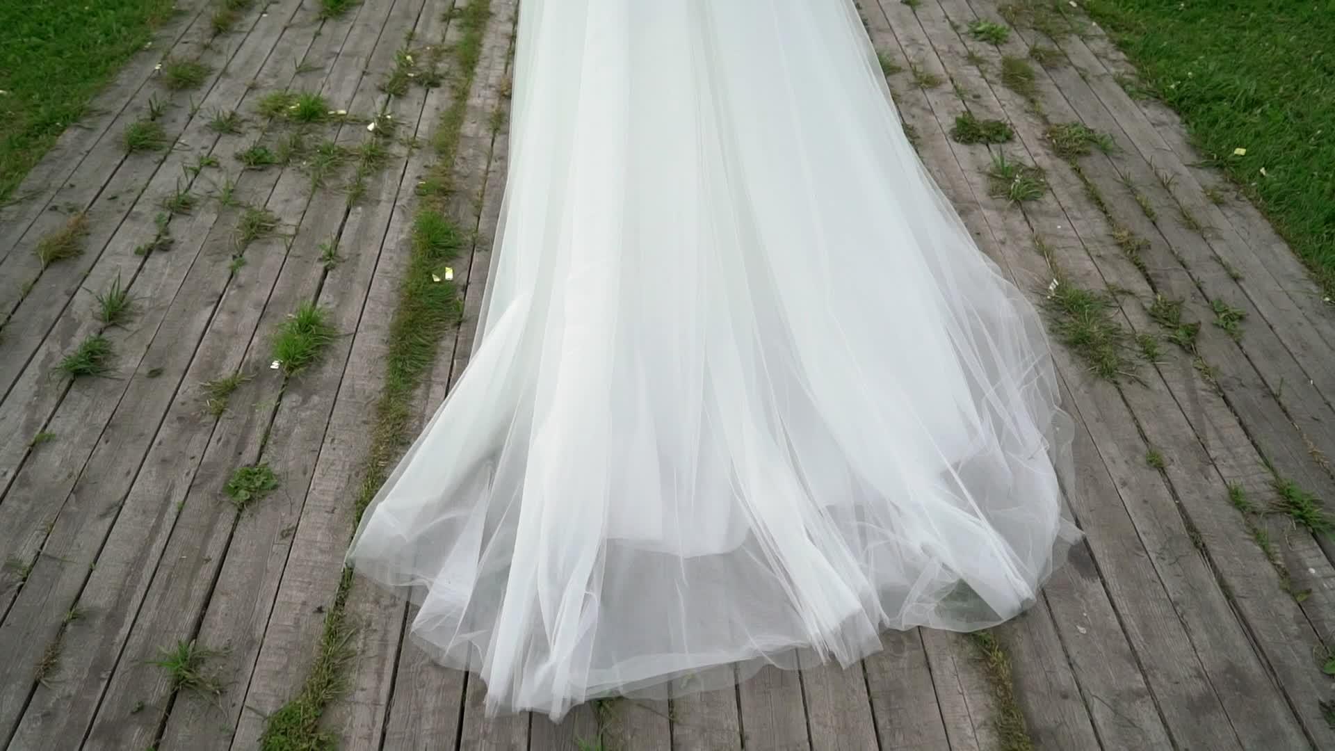 穿着结婚礼服的年轻新娘在公园里穿着白色豪华礼服视频的预览图