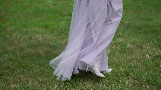 穿着结婚礼服的年轻新娘在公园里穿着白色豪华礼服视频的预览图