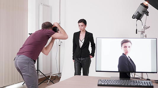 模特为摄影师摆姿势的照片显示在电脑屏幕上视频的预览图
