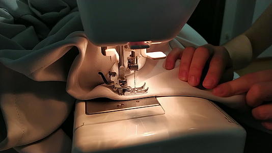 一个年轻女子的手用缝纫机缝制了一个特写镜头女人的手缝在手上视频的预览图