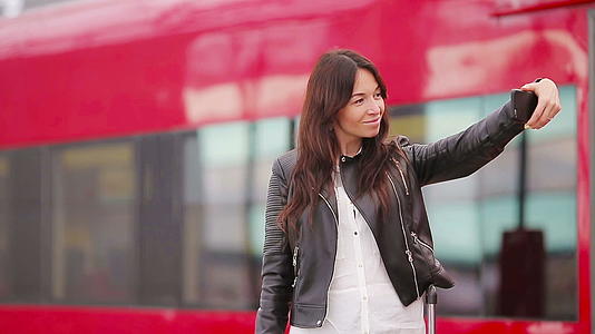 年轻女子在火车站用行李自拍高加索游客在旅行中等待视频的预览图