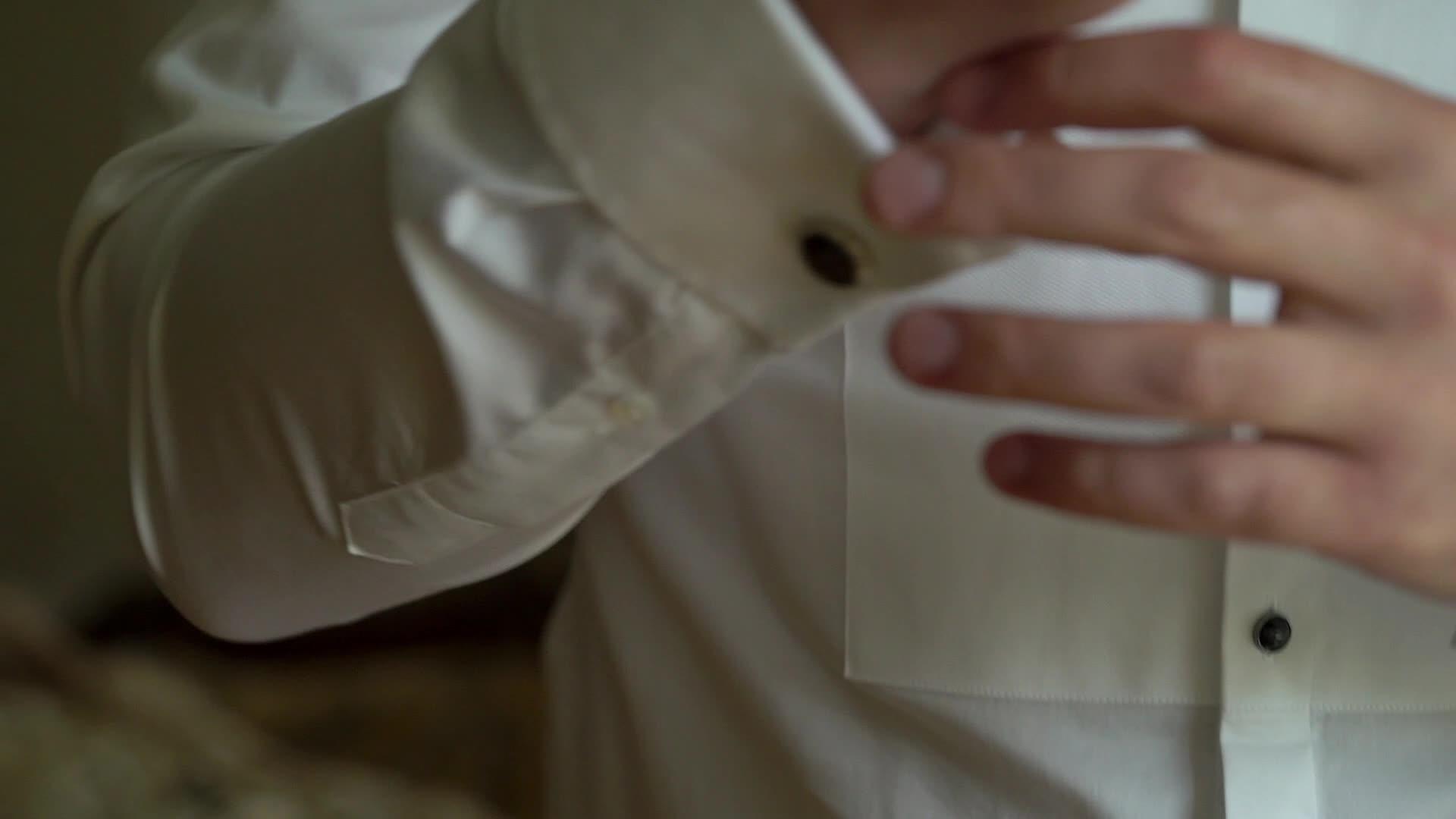 商人戴着手铐链男人穿着白色衬衫和调整袖扣视频的预览图