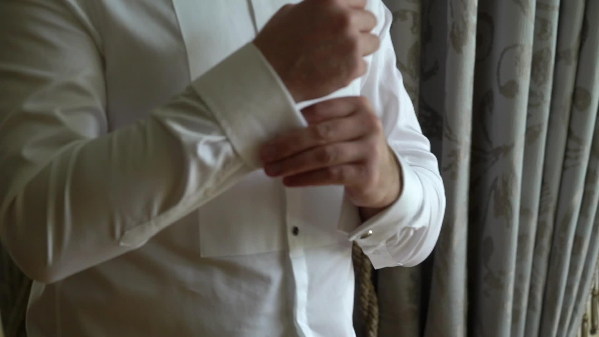 商人戴着手铐链男人穿着白色衬衫和调整袖扣视频的预览图