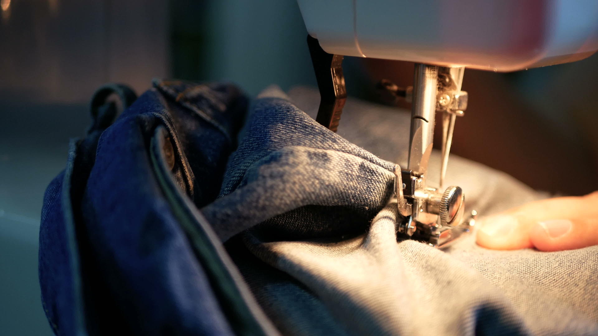 一个女人用缝纫机缝蓝色牛仔裤视频的预览图