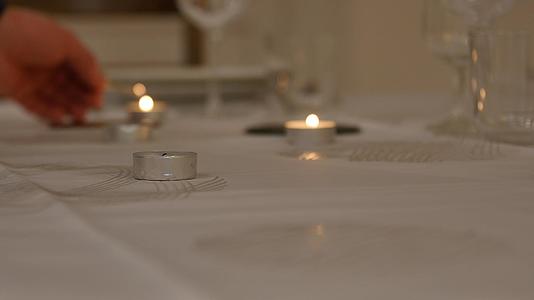 一根蜡烛在浪漫的夜晚点燃其他蜡烛在背景中浪漫视频的预览图