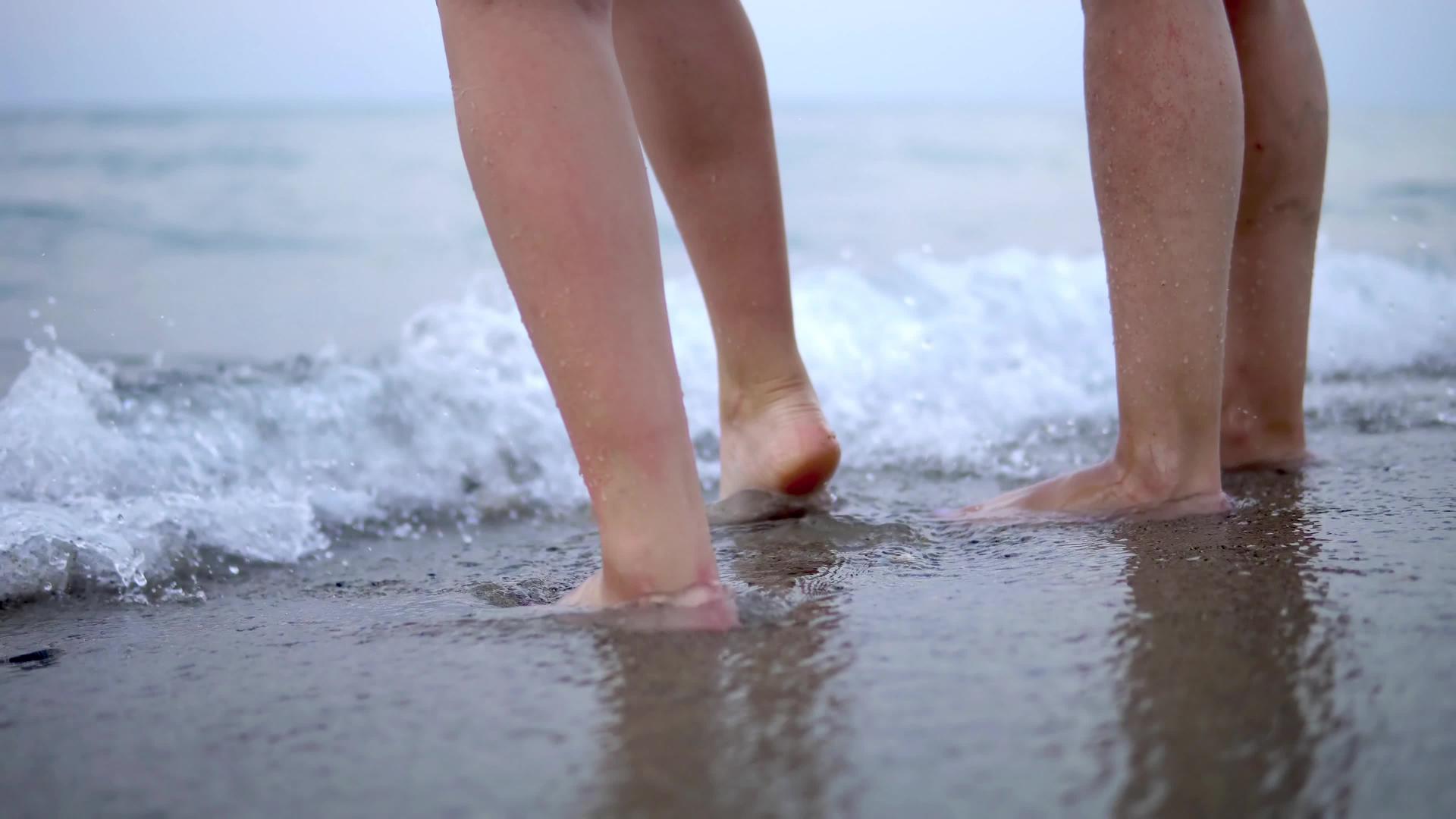 一对夫妇在海滩上跳舞双腿波浪飘动视频的预览图