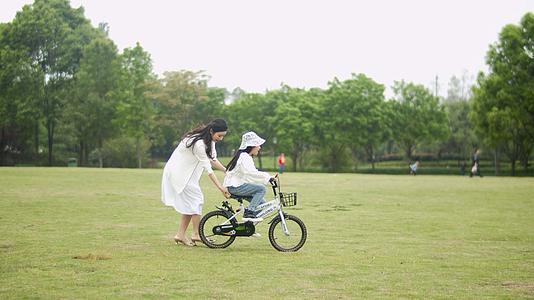 4K实拍妈妈教女儿骑自行车视频的预览图