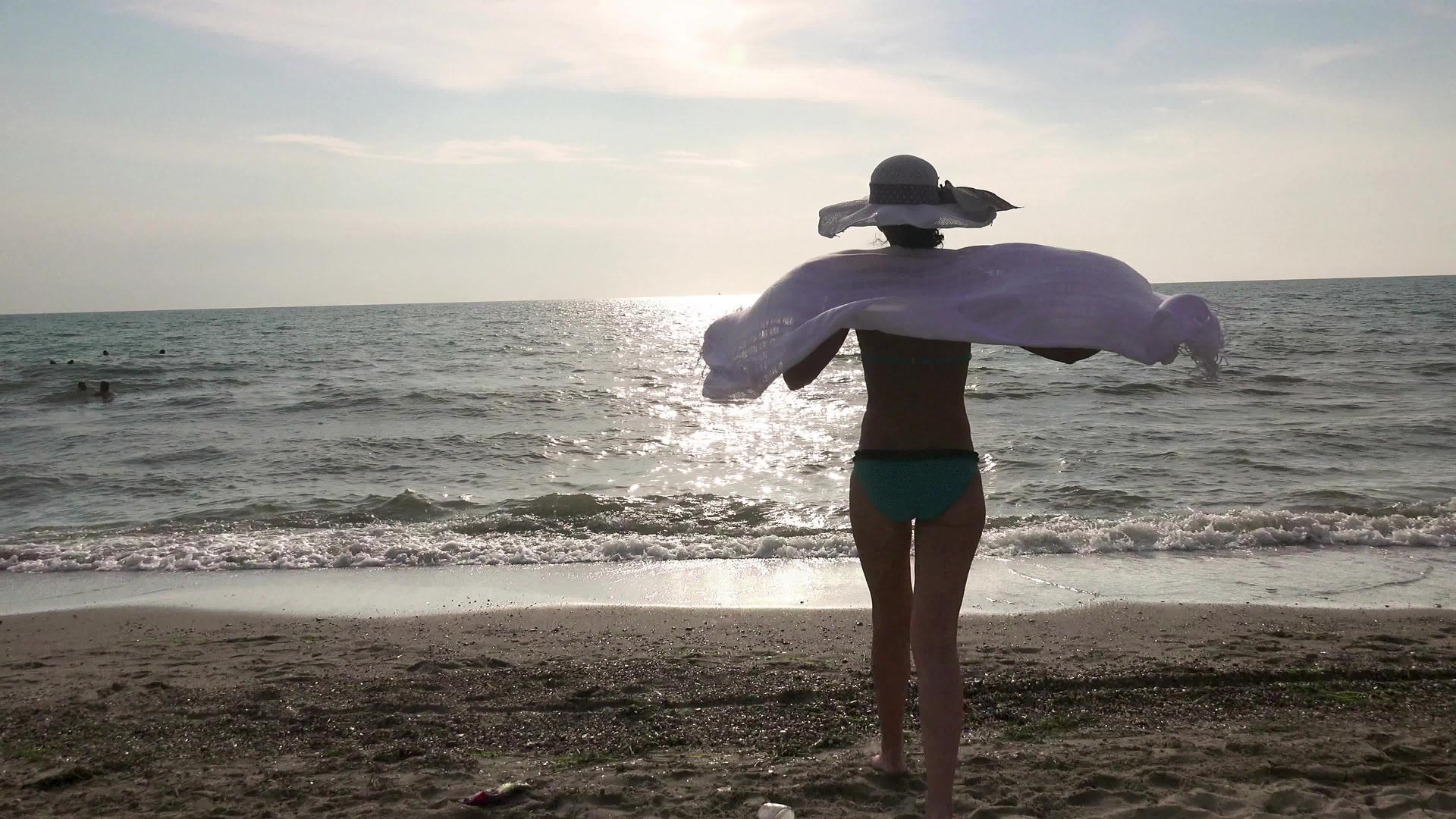 海滩边缘豪华岛日落海平线的围巾、帽子和泳衣视频的预览图