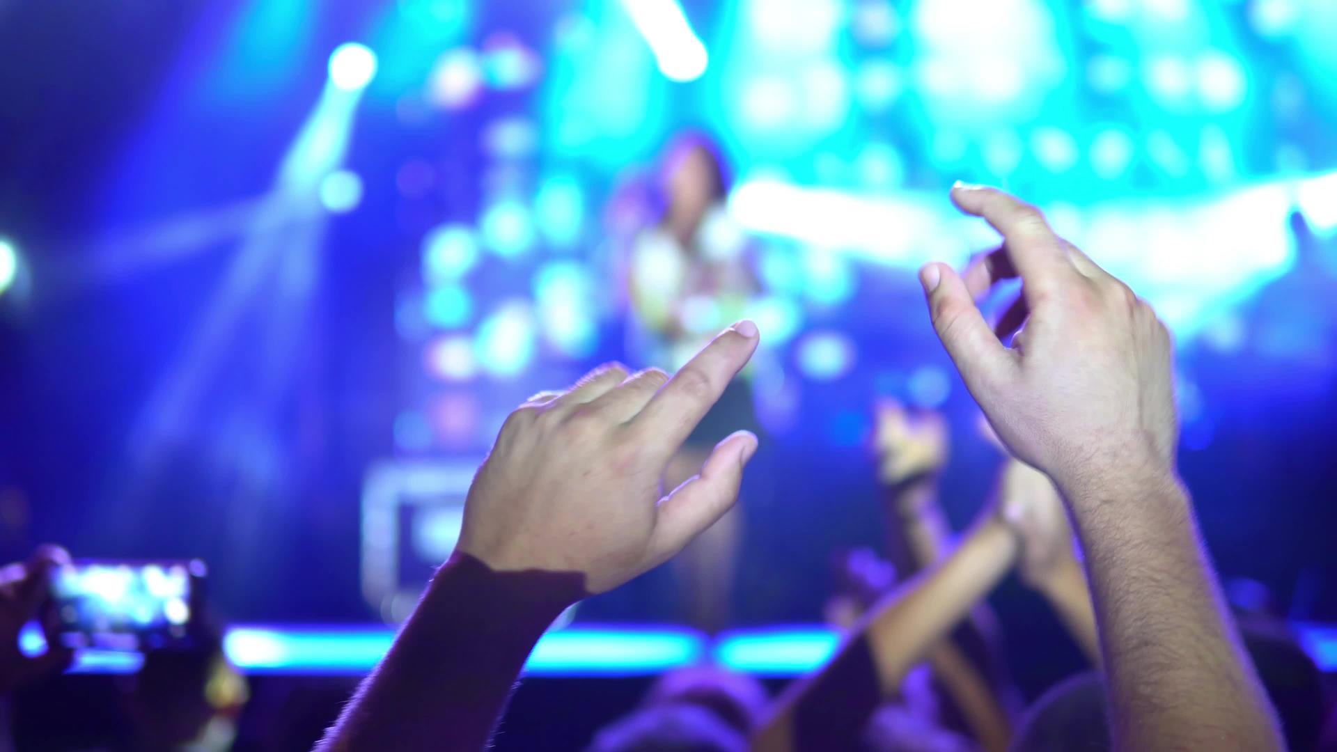 粉丝们在露天舞台上为乐队现场表演音乐会鼓掌有选择的焦点视频的预览图