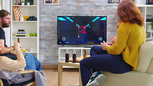 年轻女性在电视上玩电子游戏的背影视频的预览图