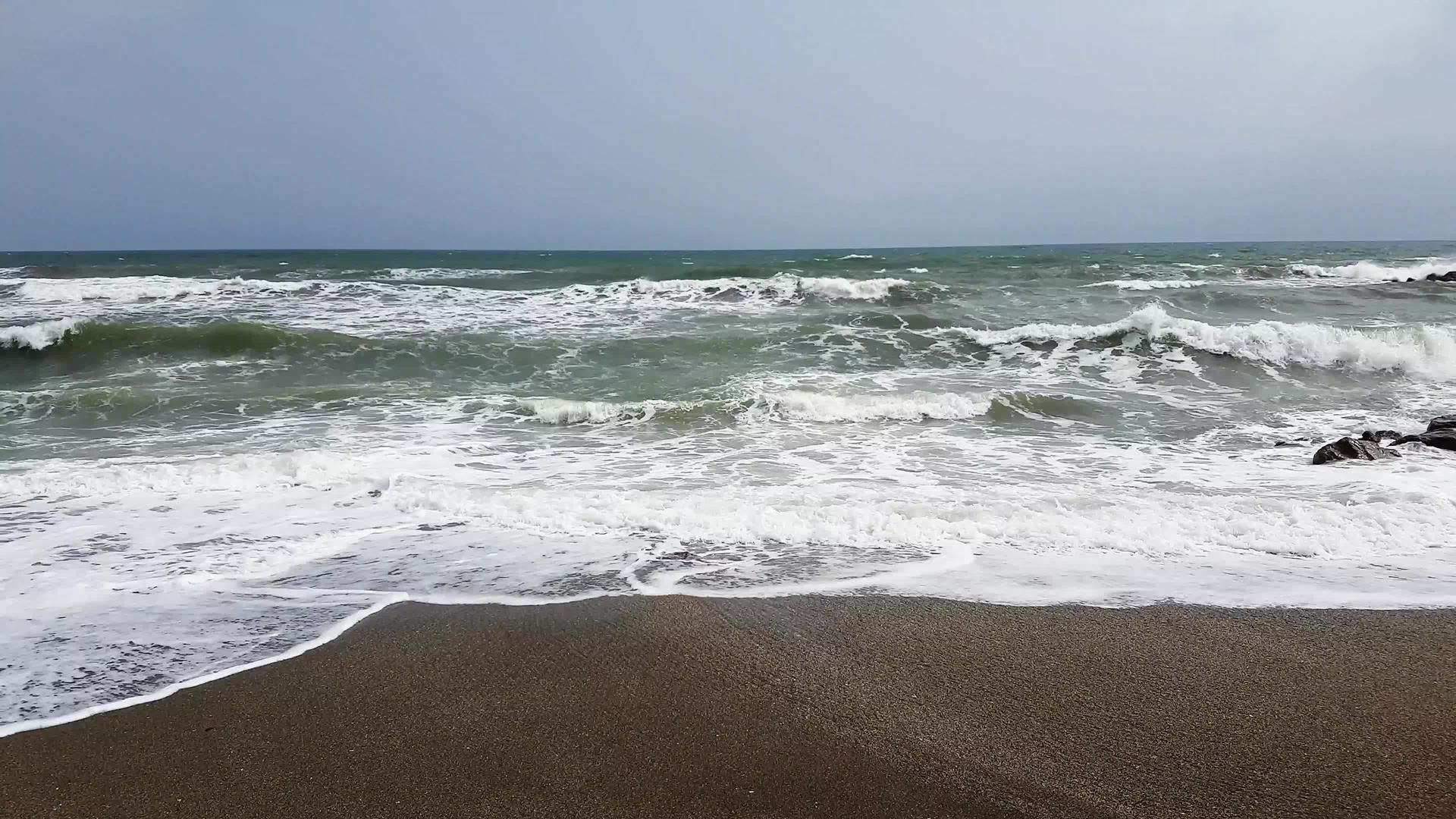 岩石海滩上的白色泡沫破碎的波浪视频的预览图