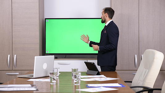 会议室的商人指绿色屏幕模拟电视的绿色屏幕视频的预览图