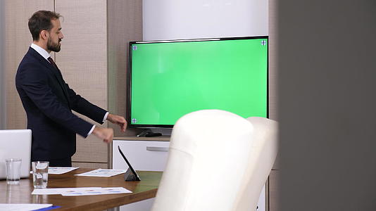 商人在绿屏电视机前说话的亮光镜头Tv视频的预览图