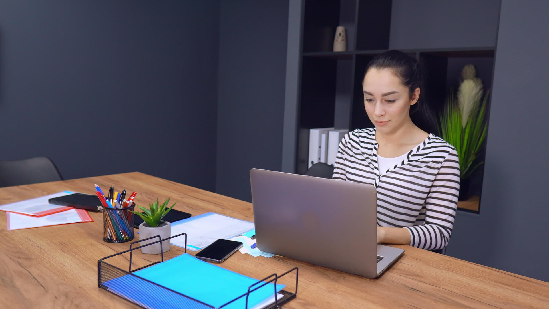 自信的女商人在现代办公室用笔记本电脑工作视频的预览图