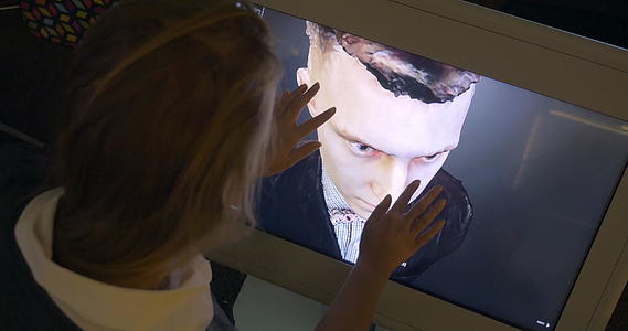 女性在触摸屏监视器上观看3D人体模型视频的预览图