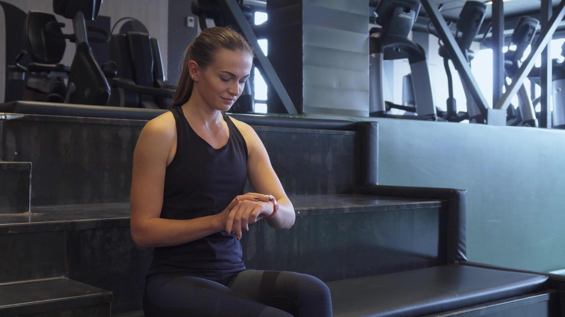 健身女孩在体育锻炼时用手表做第二手手表视频的预览图
